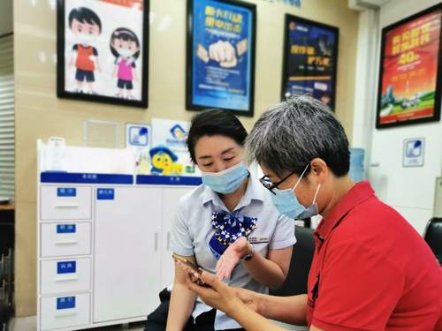 建行成都第六支行，大堂經(jīng)理為客戶介紹手機(jī)銀行&ldquo;大字&rdquo;模式